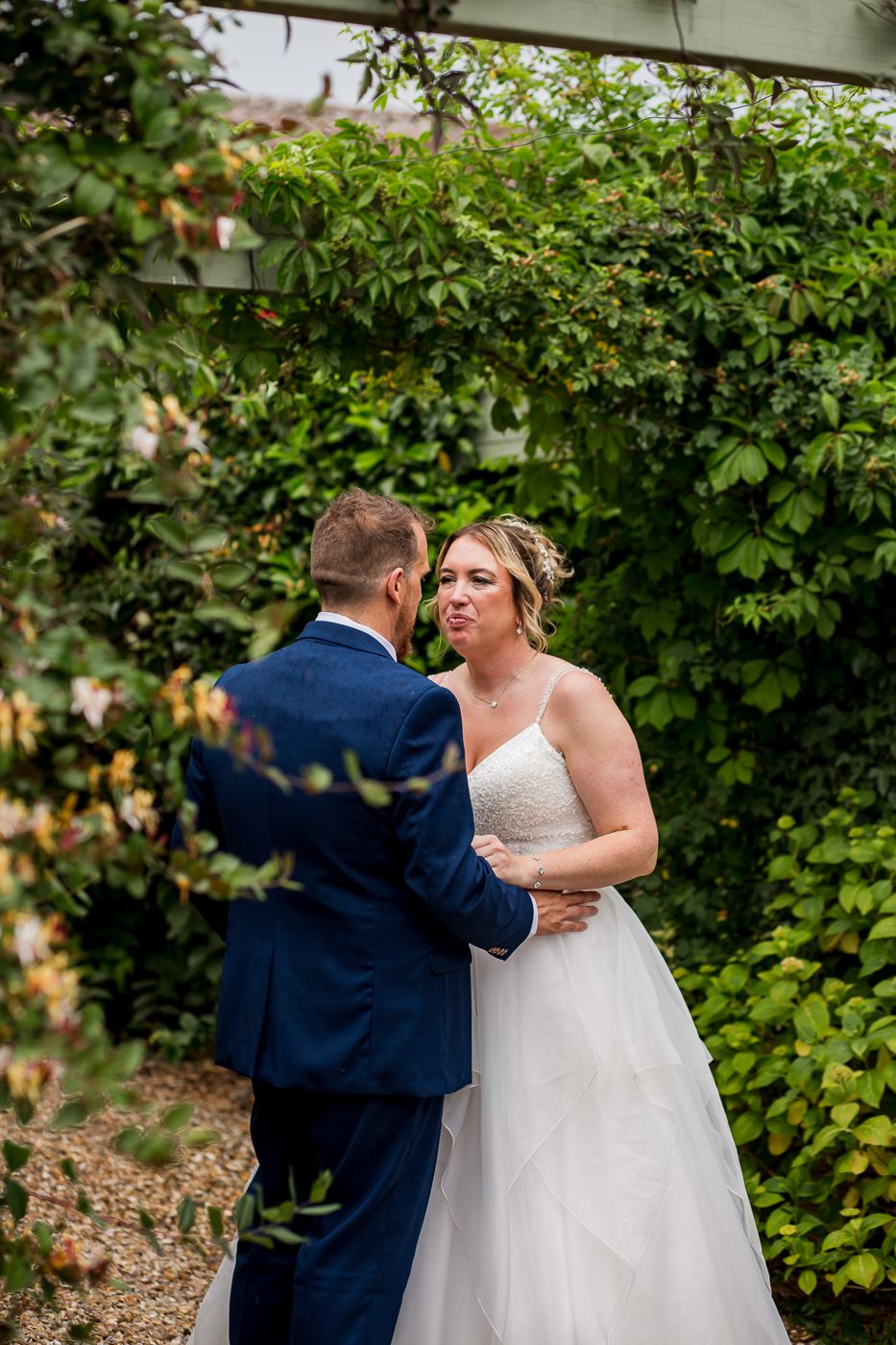 Candid wedding moments captured in garden setting with lush greenery and natural lighting.