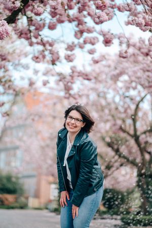 A joyful moment captured under blooming pink cherry blossom trees on a spring day.