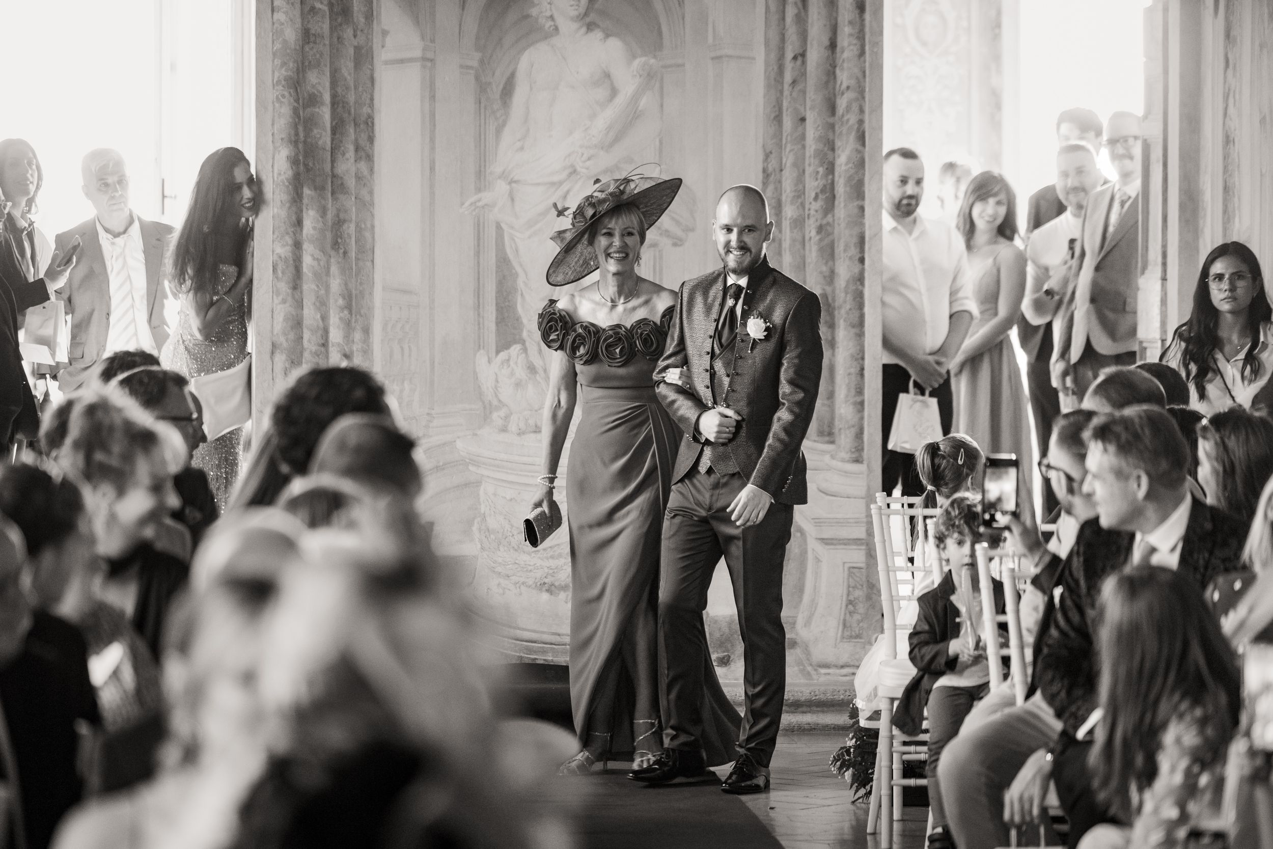 Wedding guests dance and celebrate on an elegant ballroom dance floor during an evening reception.