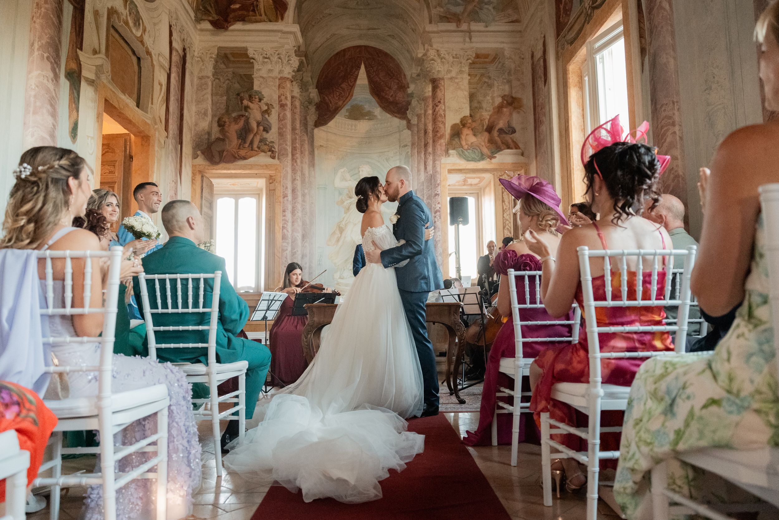 Elegant wedding venue interior showcases ornate decor with white chairs and romantic lighting for a luxurious celebration.