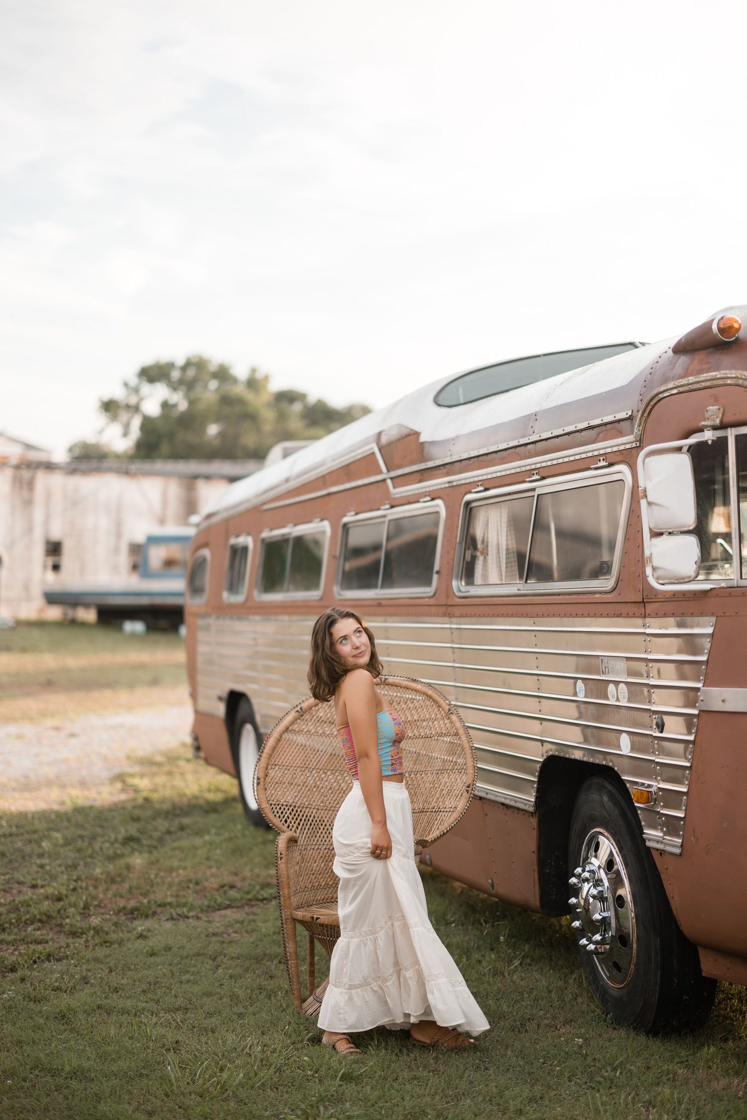 A vintage brown station wagon parked on grass serves as a backdrop for outdoor wedding photos.
