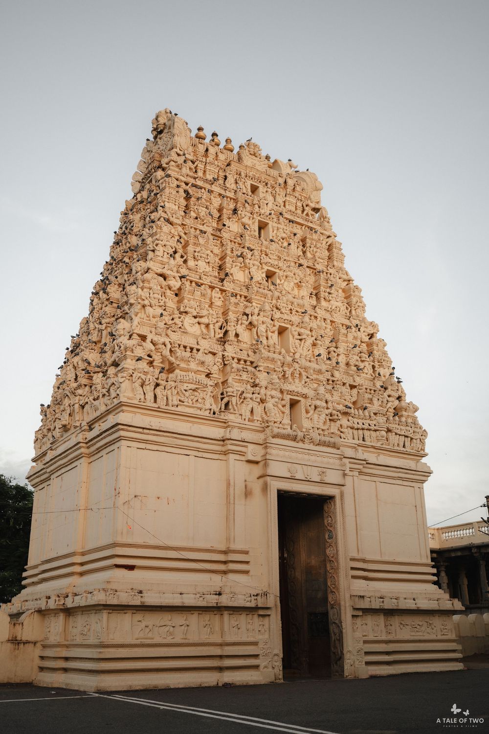 Ancient Hindu temple architecture featuring ornate gopuram towers with intricate carvings in a warm beige stone.