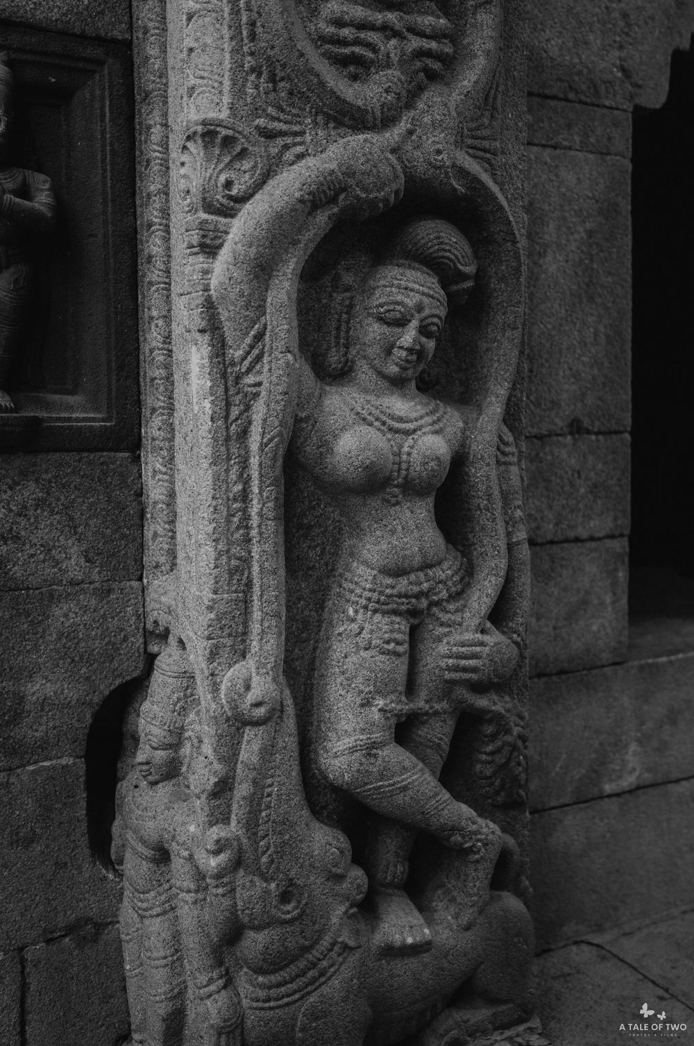 Black and white photo of an ancient Hindu temple stone carving depicting a female deity with intricate details.