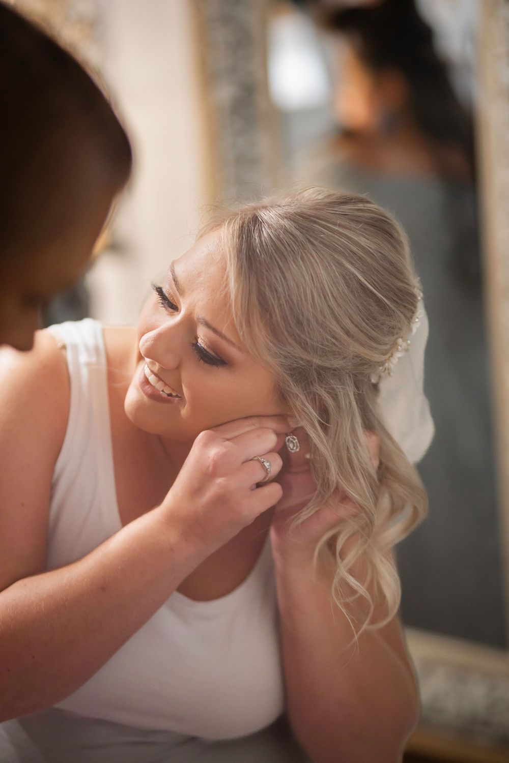 Soft natural light illuminates a tender moment during wedding preparations.