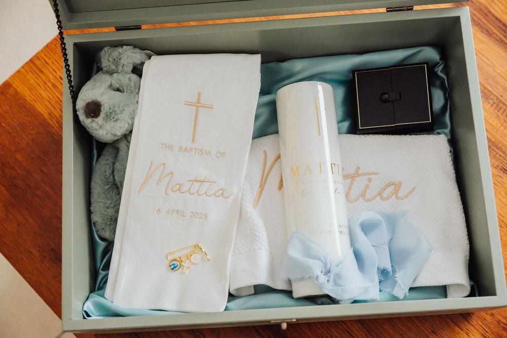 A collection of white baby memory boxes and keepsake items arranged in drawers with soft blue accents.