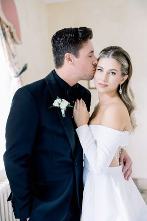 Elegant couple in formal wedding attire sharing intimate moment.