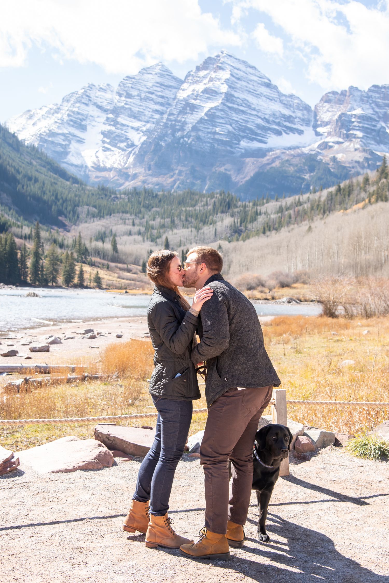 A romantic proposal moment with their dog at Maroon Bells in Colorado, snow-capped mountains rising majestically behind them.
