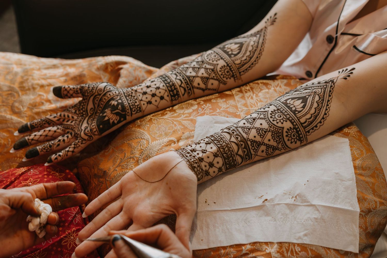 Intricate henna designs adorning hands in traditional Indian wedding preparation.
