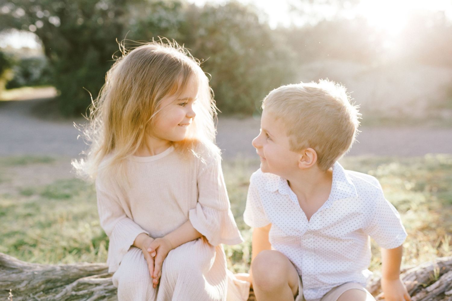 A couple shares tender moments in a sunlit outdoor setting during a romantic photo session.