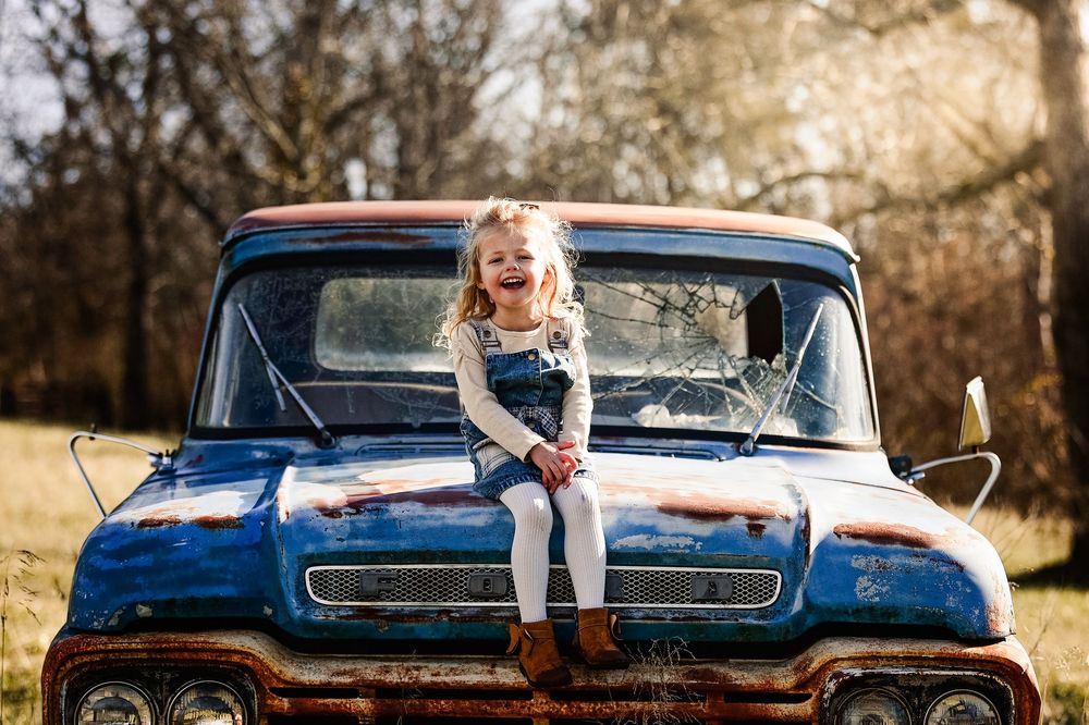 A classic blue vintage pickup truck parked outdoors during a fall photoshoot session.