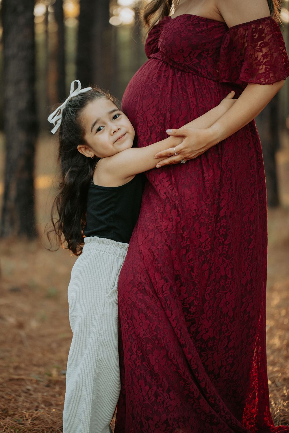 child hugging pregnant mother
