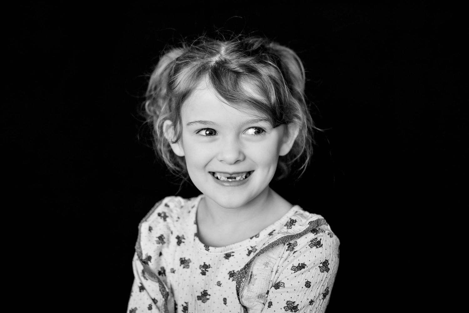 Black and white studio portrait with floral pattern dress.