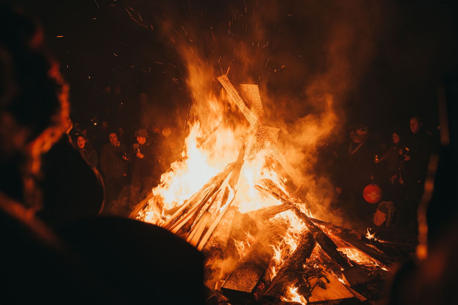 Close-up shot of roaring bonfire flames against dark background.