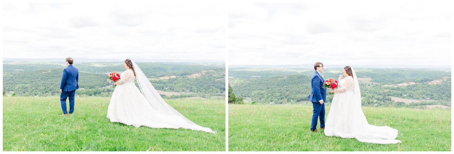 A couple shares a romantic moment on a hilltop overlooking a scenic countryside landscape on their wedding day.