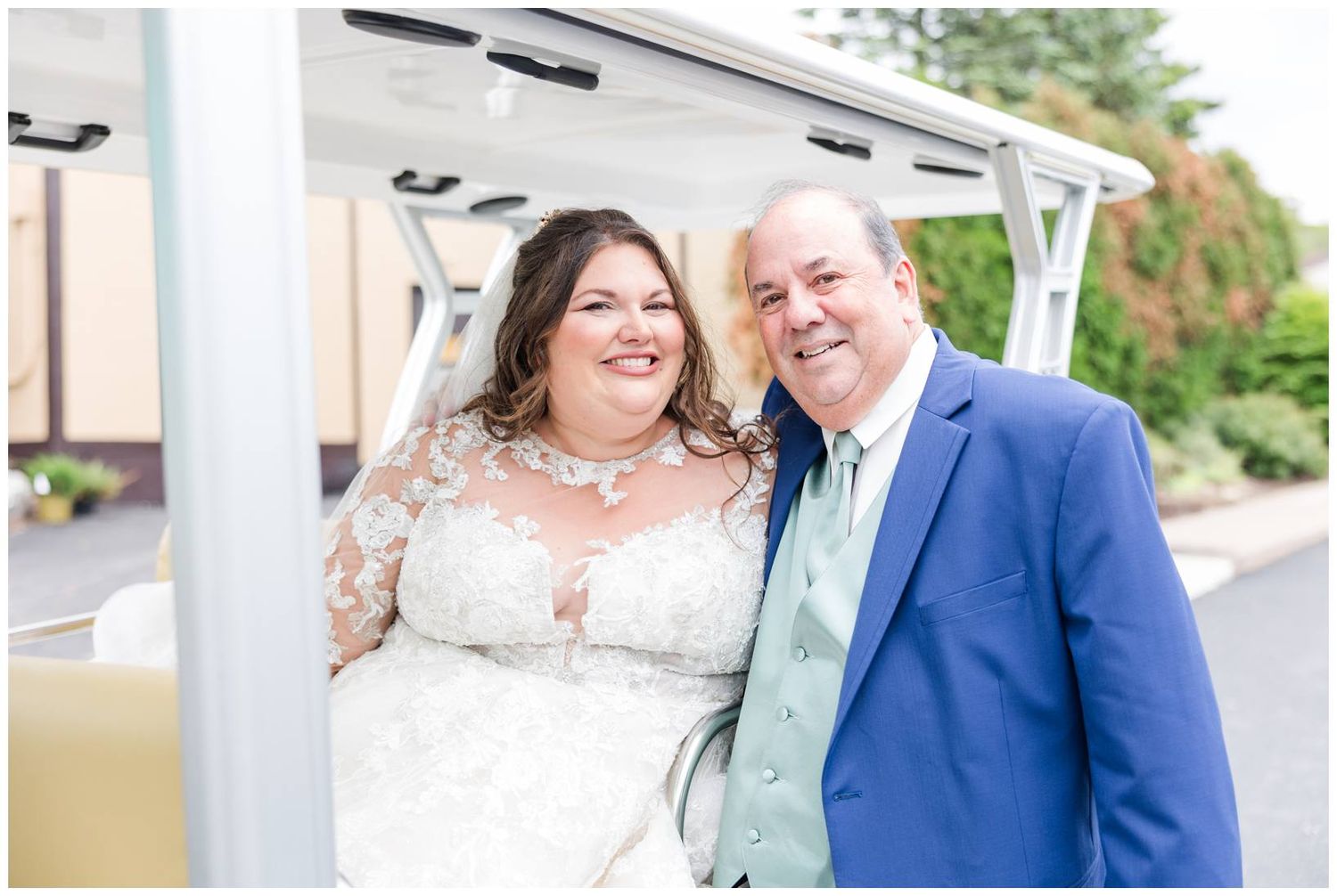 Newlyweds pose together under white pergola on their wedding day.