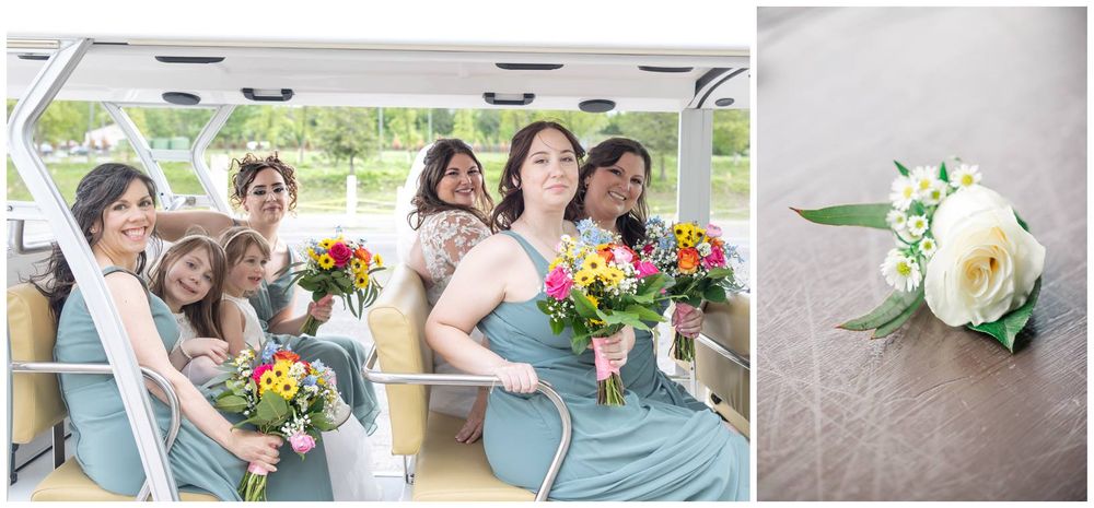 A wedding party in light blue dresses sits together holding vibrant orange and pink floral bouquets.