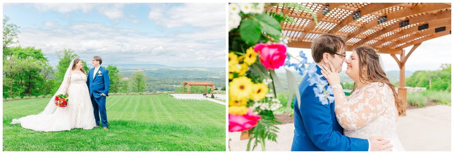 Couple embraces outdoors under rustic pergola with colorful balloon arch and scenic mountain views in background.