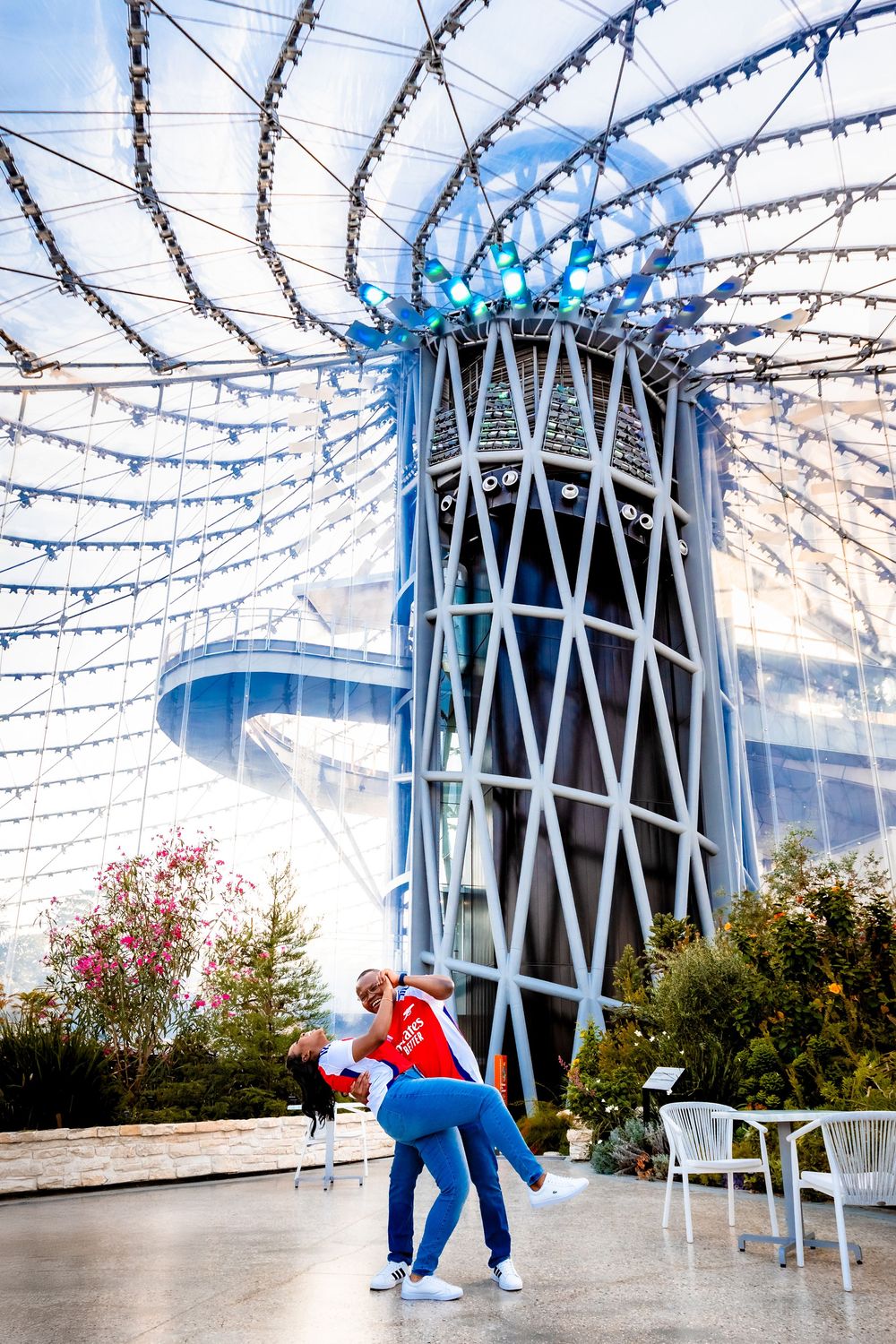 Modern architectural structure with blue lighting and decorative string lights creating a romantic holiday ambiance.