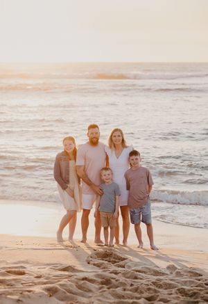 Family of five stand on beach with sun setting behind them for Mandurah Family Photographer, Story & Soul Photography. Mandurah WA