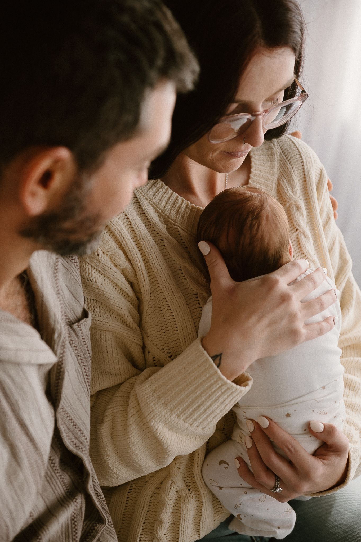 A couple tenderly gazes at their newborn baby for newborn photographer Story & Soul Photography in Mandurah WA