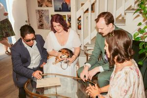 A small group gathers around a table sharing a celebratory moment indoors.