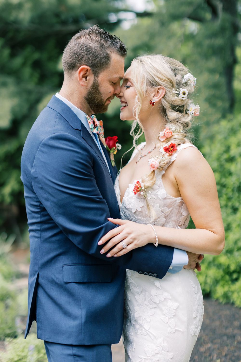 A romantic moment between newlyweds sharing an intimate embrace in their wedding attire against a lush garden background in Orange County NY