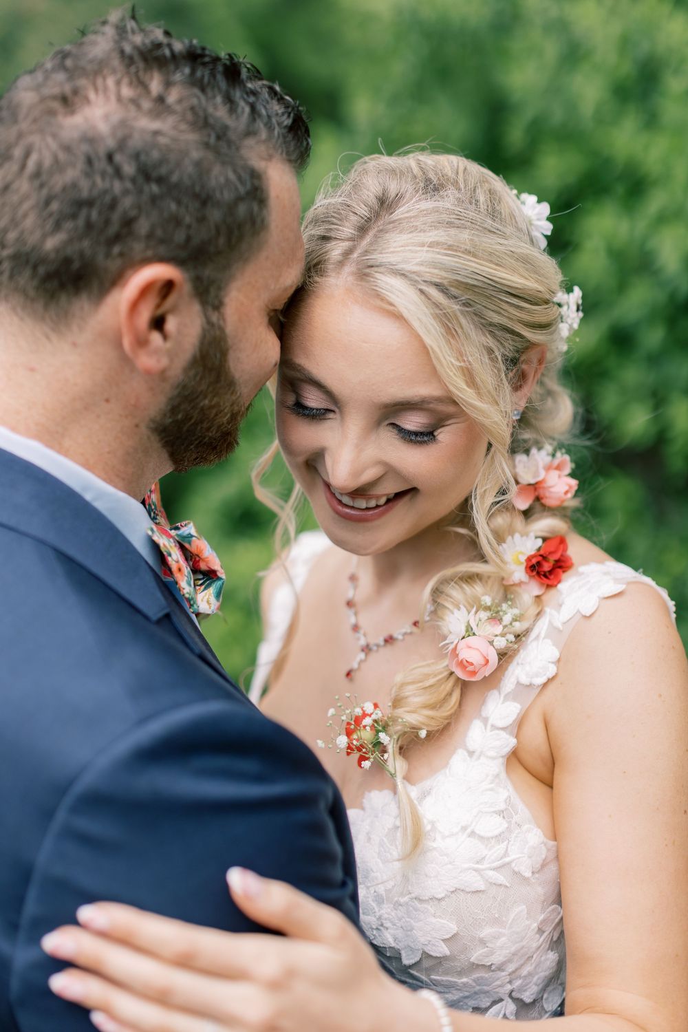 A romantic wedding moment captured in a garden setting with floral hair accessories in Orange County, New York.