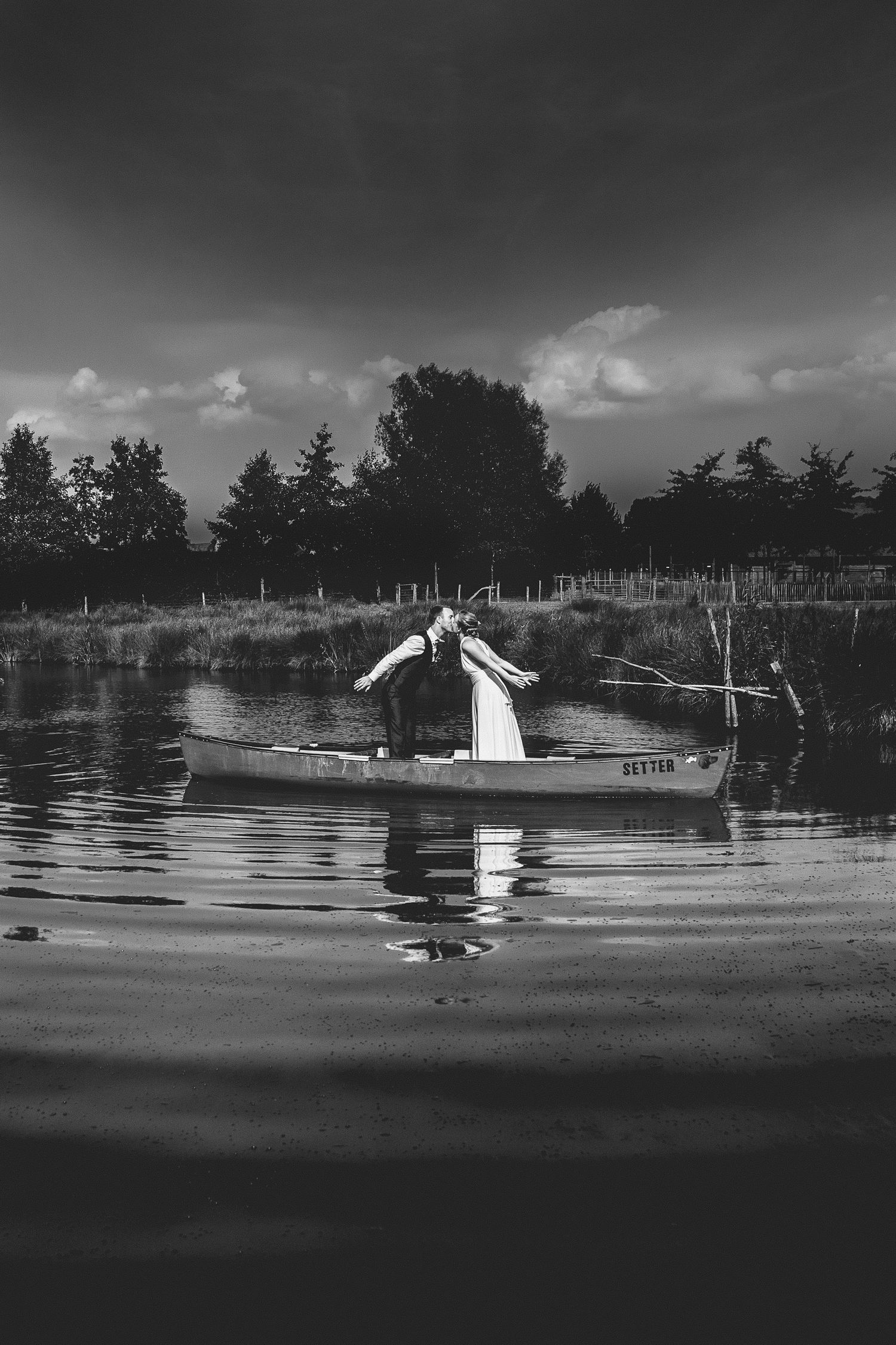 Small boat on calm water with reflection in black and white. Wedding photography meets storytelling.