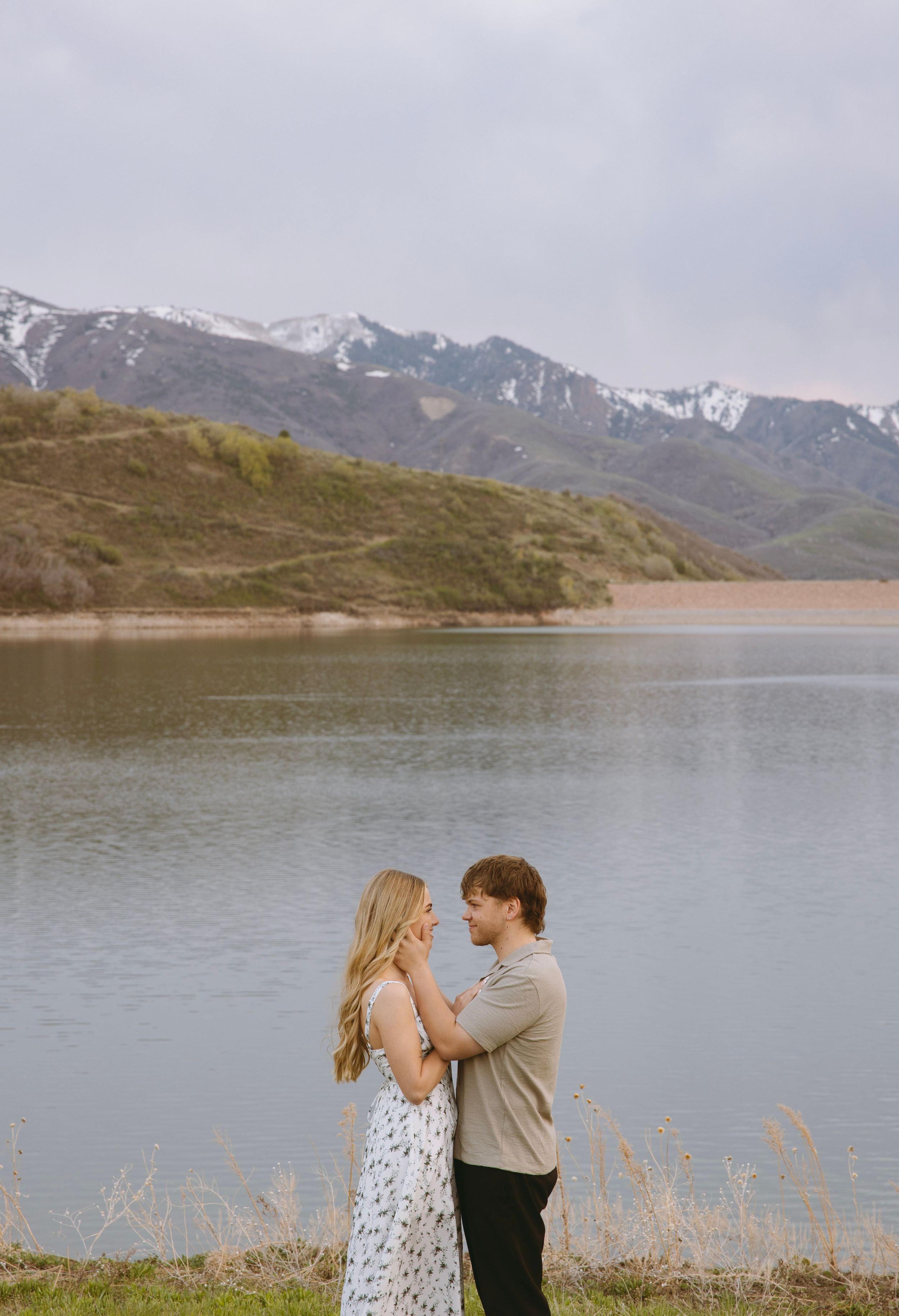 A tender moment shared by a mountain lake with snow-capped peaks in the background in Salt Lake City, Utah.