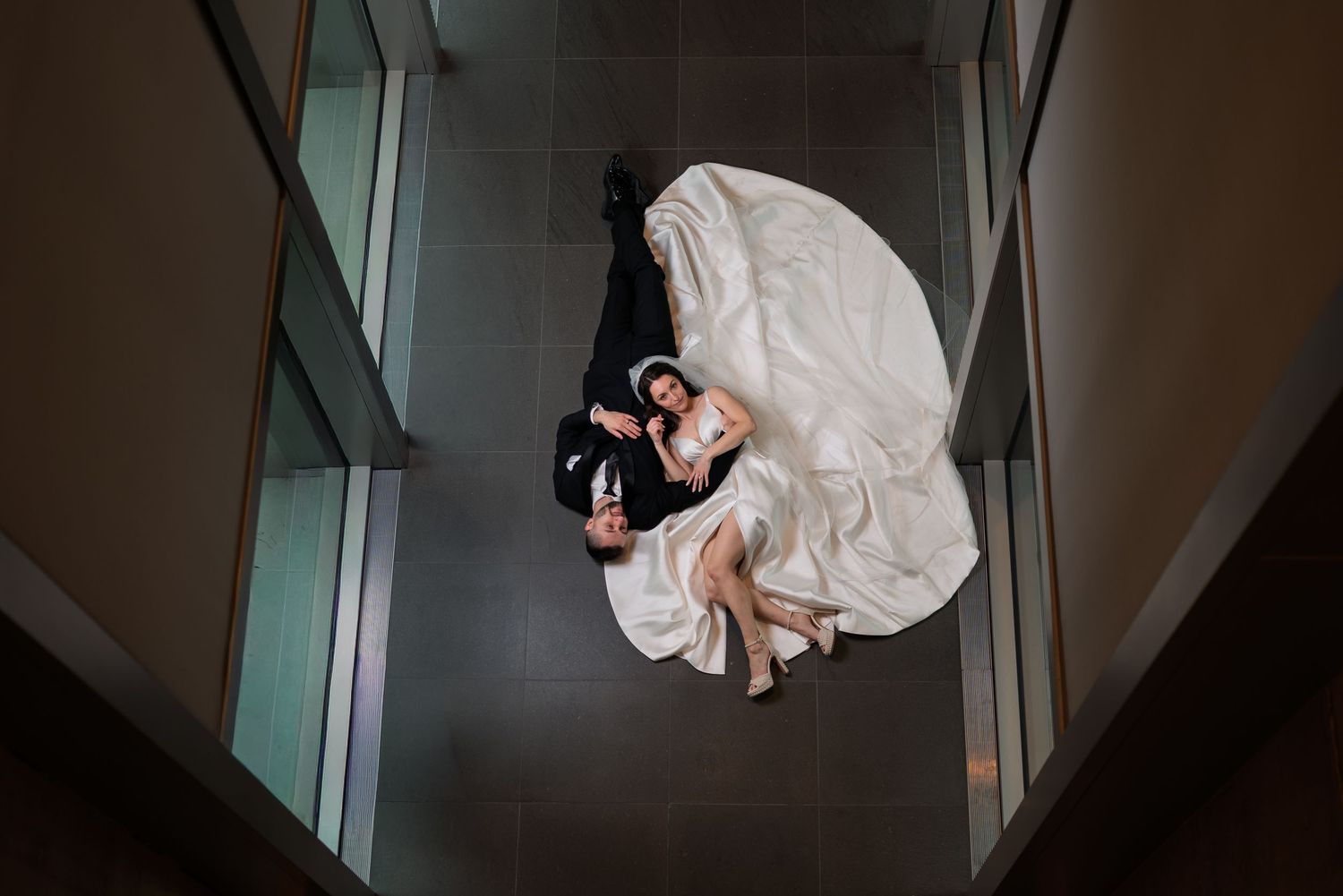 A romantic rooftop wedding moment with a bride in a flowing veil and groom embracing against downtown Grand Rapids Skyline
