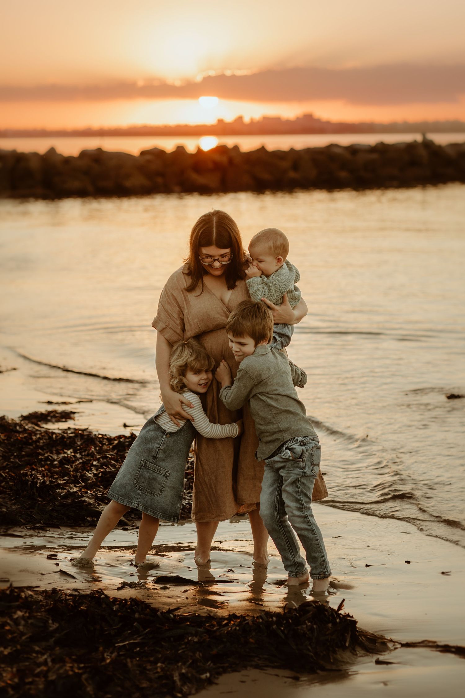 Family photoshoot enjoying sunset together at beach with warm golden in Sydneys Kurnell