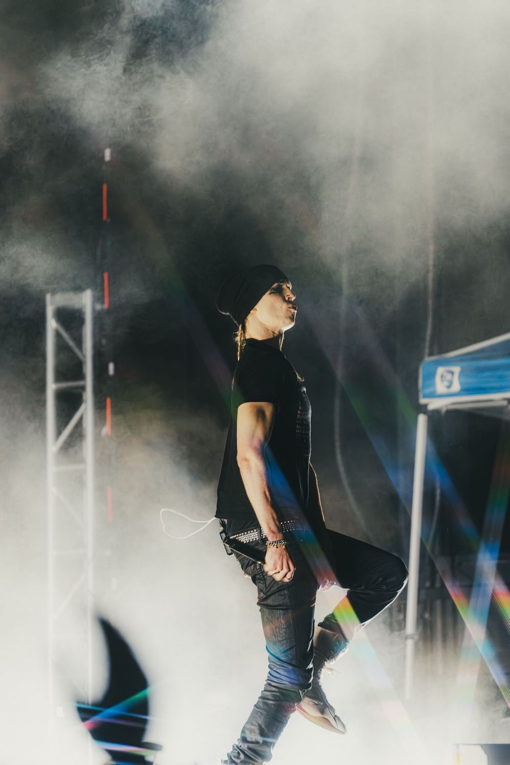 Performer on stage surrounded by atmospheric smoke effects during a concert performance.