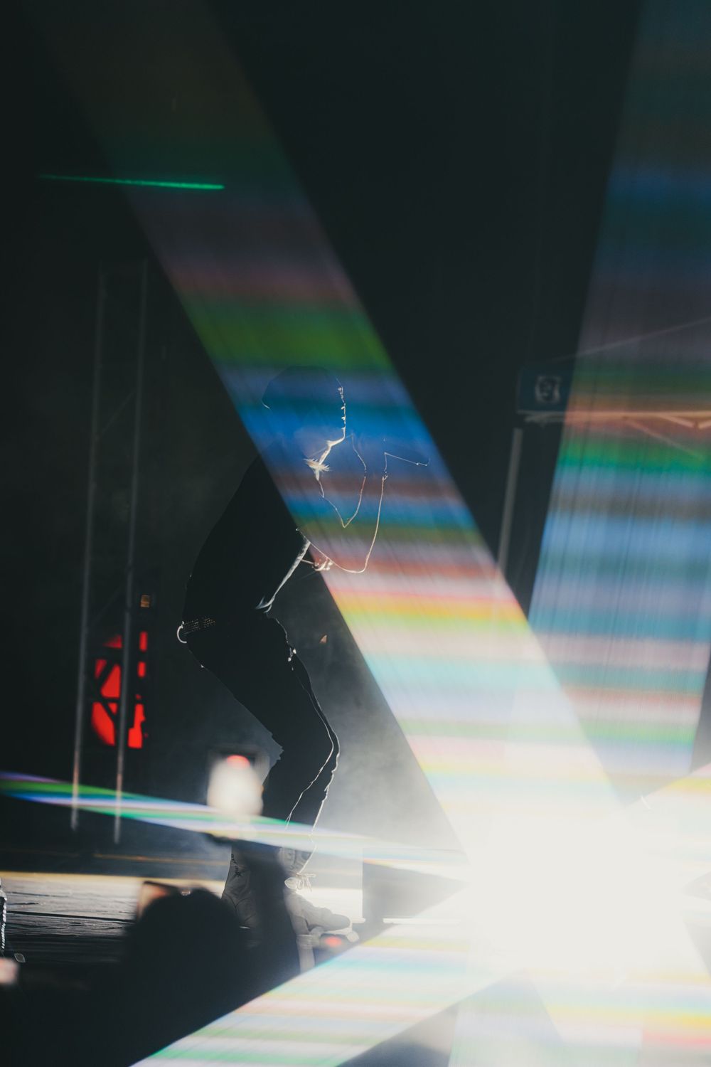 Abstract light patterns create a dynamic visual effect against a dark background with prismatic colors and shadows.