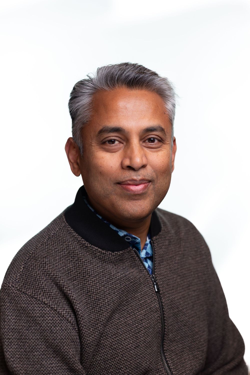A series of four headshots showing someone wearing a brown tweed jacket making different facial expressions.