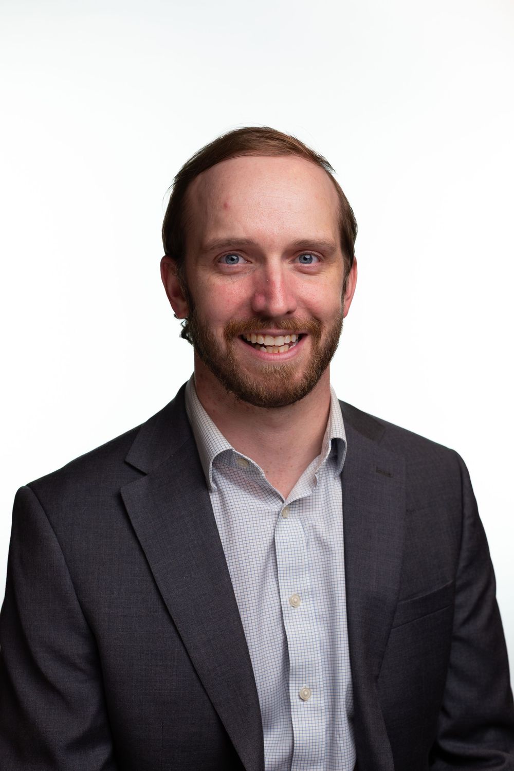 Professional headshot series showing the same person in four similar poses wearing a dark suit and light shirt.