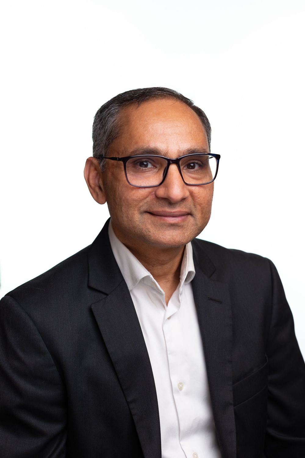 Professional headshot portraits of someone in glasses and black suit against dark background from multiple angles.