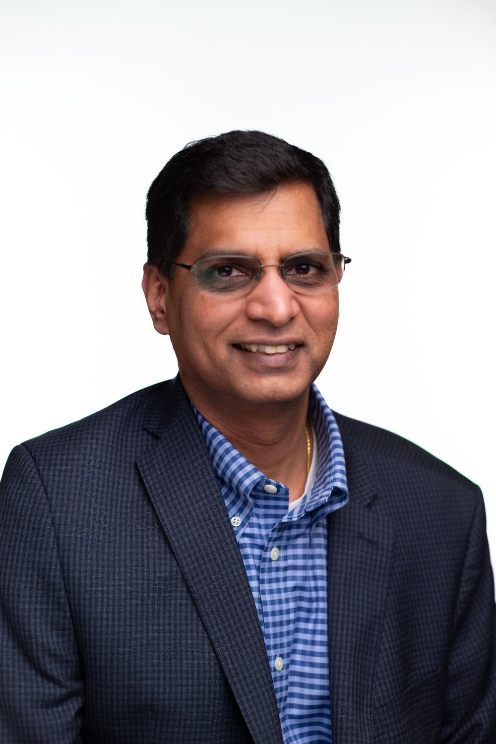 Professional headshot series showing same person in blue checkered shirt and dark blazer with varying expressions.