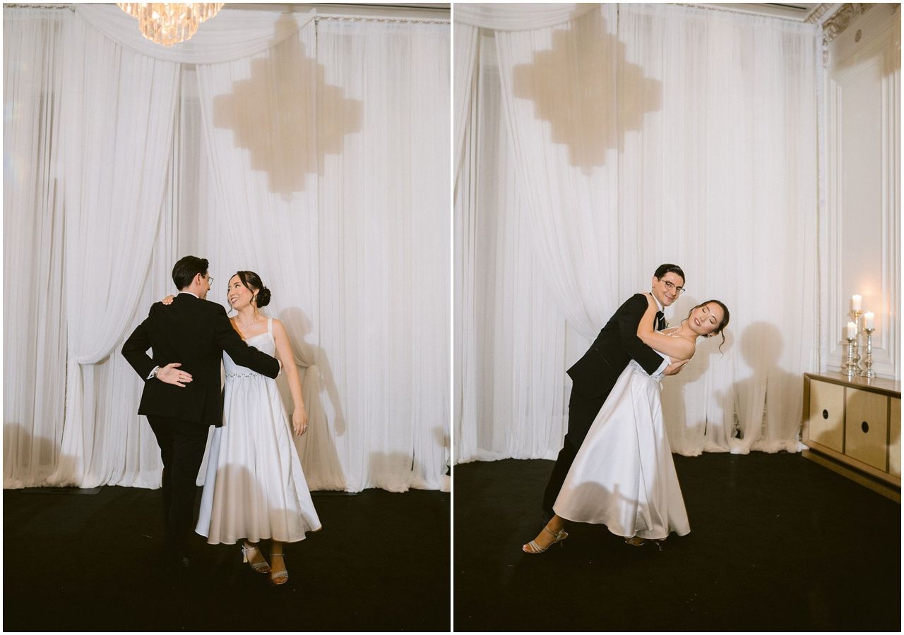 A couple dances gracefully as first dance against a white curtained backdrop.