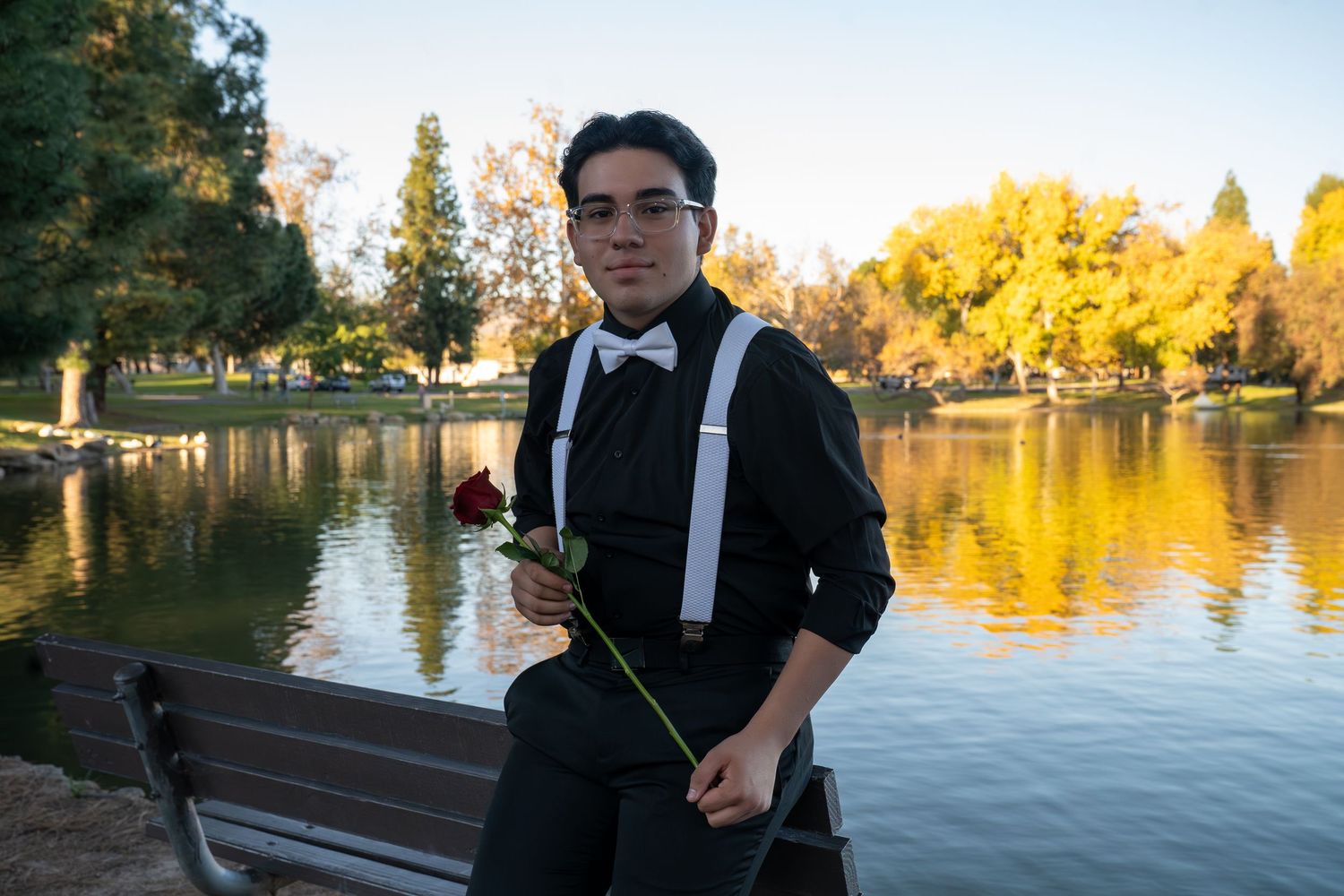 A series of lakeside photos at sunset showing autumn trees reflecting in calm water with a person in formal attire.