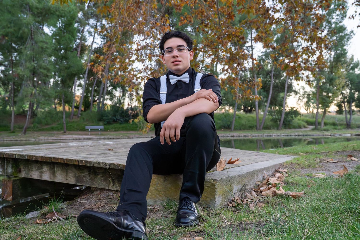A series of photos showing a person in black attire sitting on concrete steps surrounded by autumn foliage.