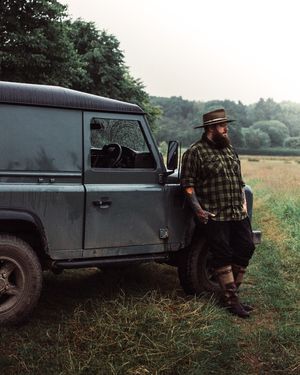 Vintage truck parked in tall grass field during moody outdoor photo session.