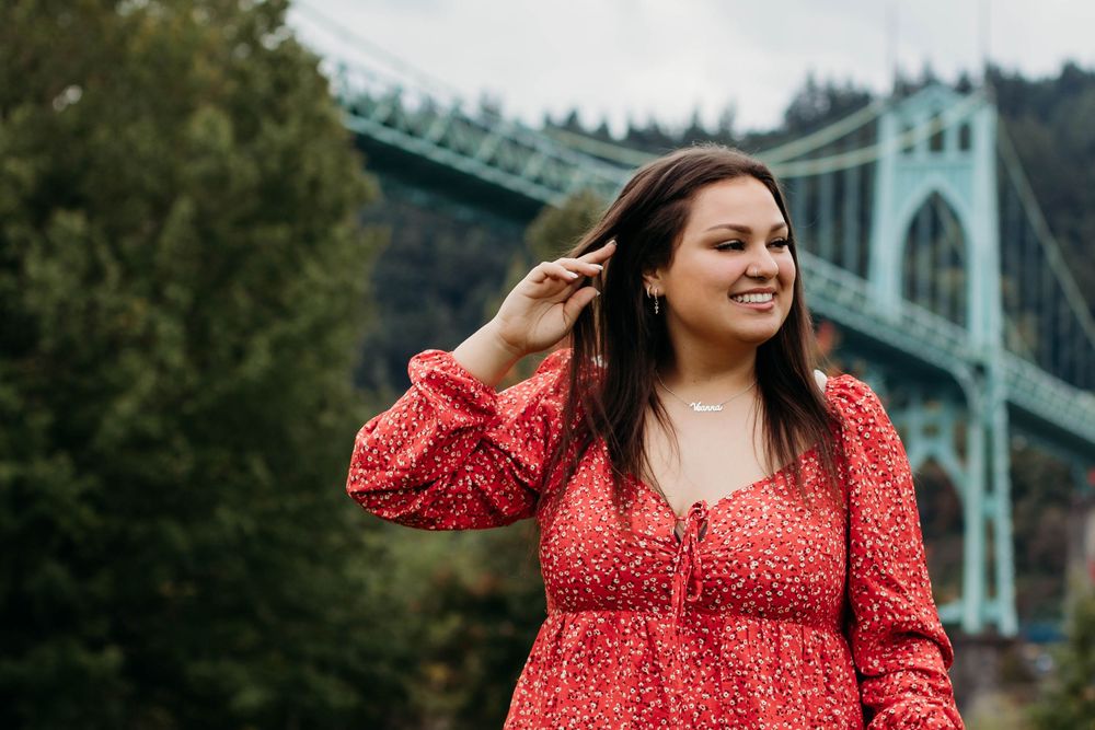 Portrait series against architectural backdrop featuring red dress and St. Johns Bridge.