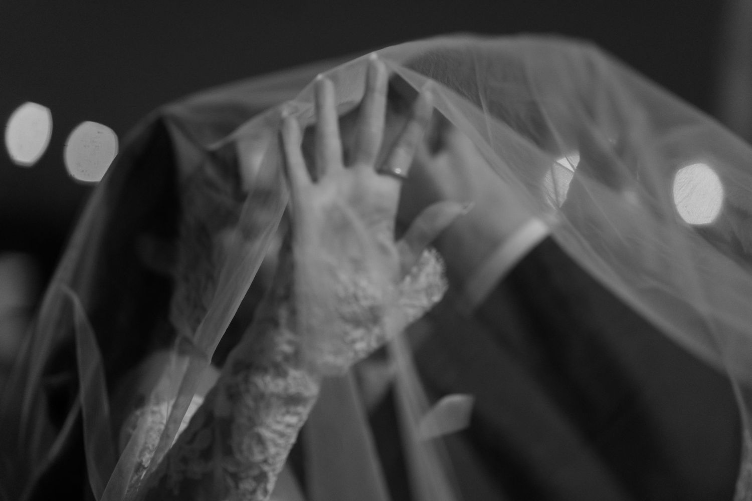 A close-up of hands playing a piano keyboard with soft bokeh lighting effects in the background.