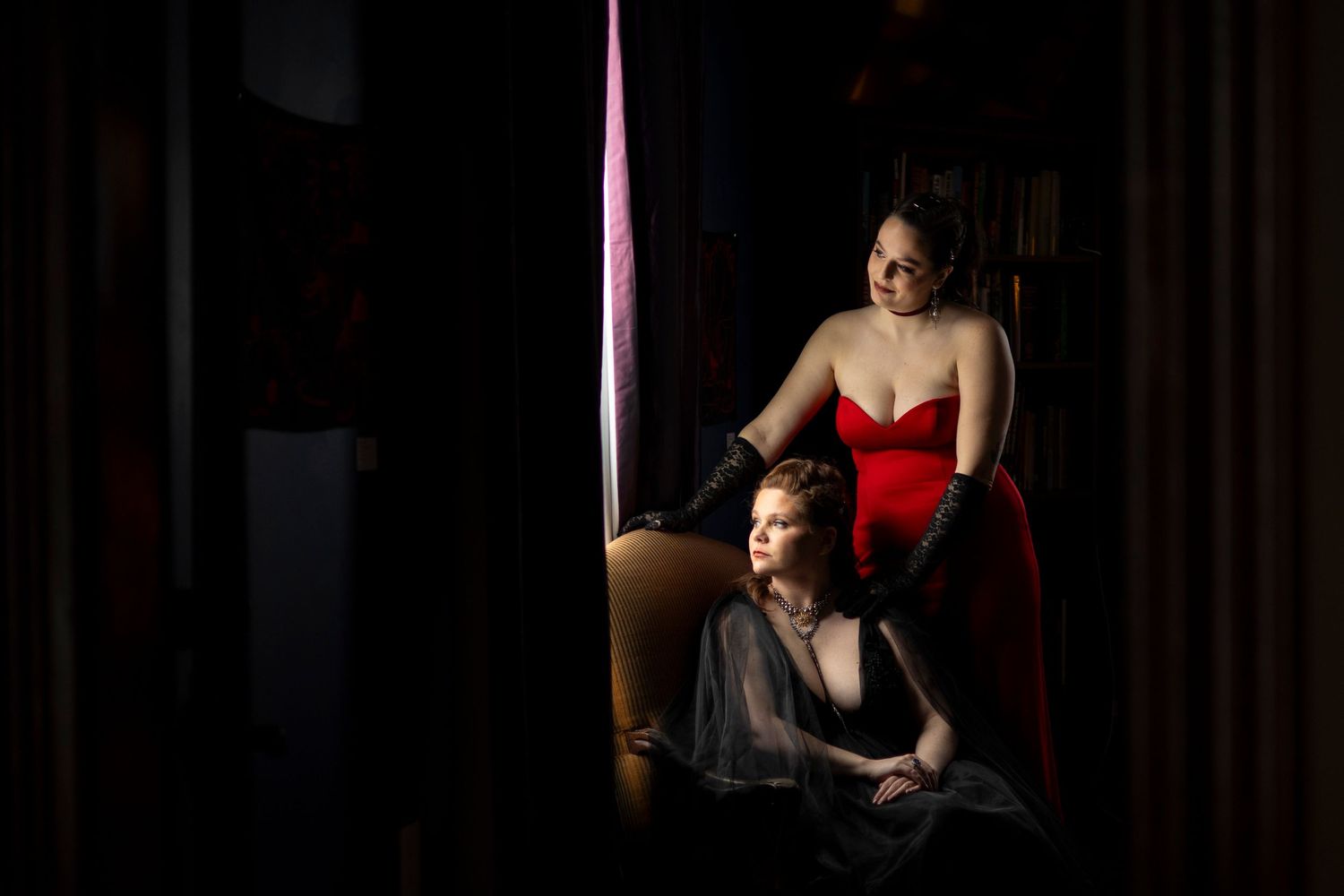 A queer female couple look out the window for their bridal portraits in an alternative wedding venue in northern Massachusetts.