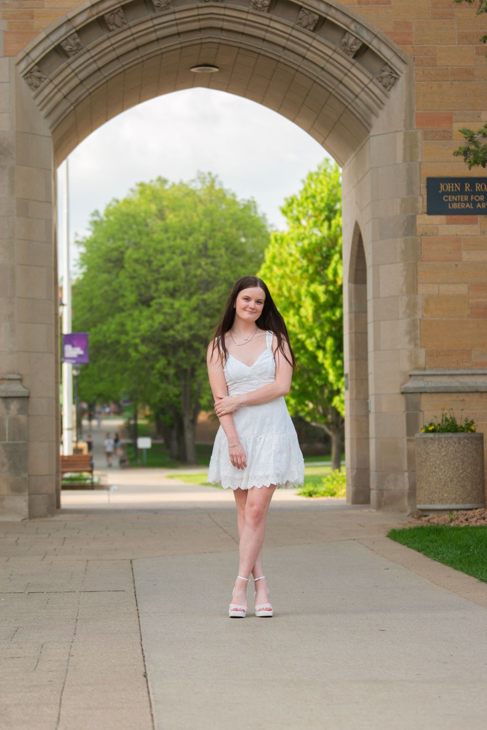 A series of photos showing a person in a white dress posing under a brick archway.