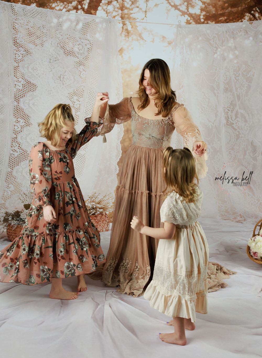 A collection of feminine dresses in muted brown and cream tones displayed in a rustic setting with textured walls.