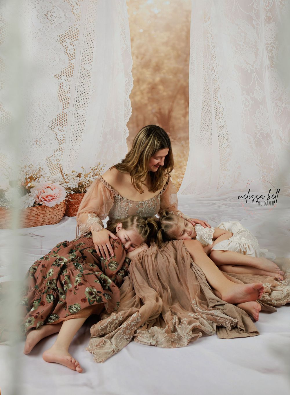 Ethereal portrait in soft peach tones with flowing vintage dress and lace curtains creating dreamy atmosphere.