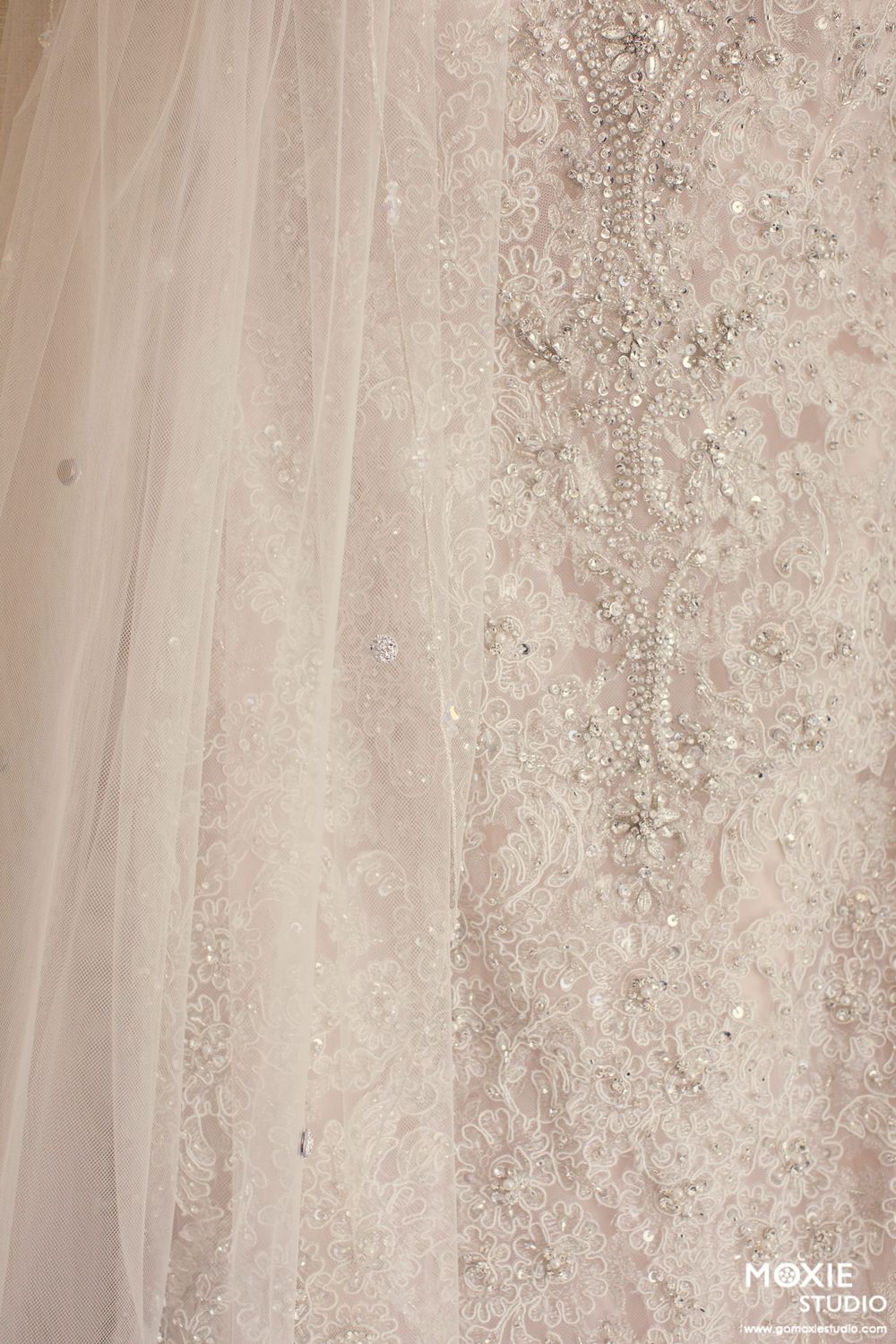 Close-up detail of an elegant beaded wedding dress with delicate lace and sequin embellishments in soft champagne tones.