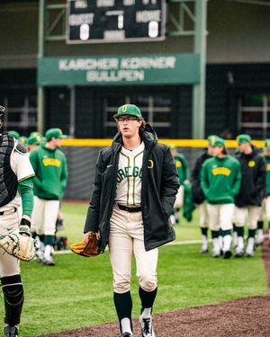 Baseball players in green and white uniforms practice on a field near Karcher Korner.