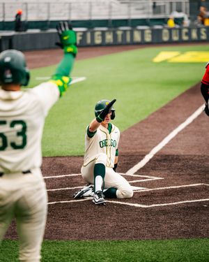 Baseball player executes bunt technique at home plate during game.